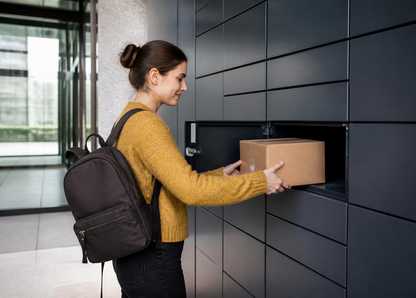 Medewerker pakt een pakket uit een geopend vak van een pakketlocker
